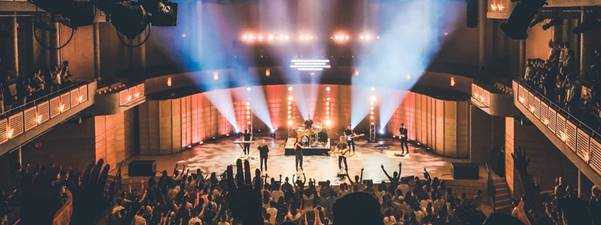 people standing on stage with lights turned on during nighttime