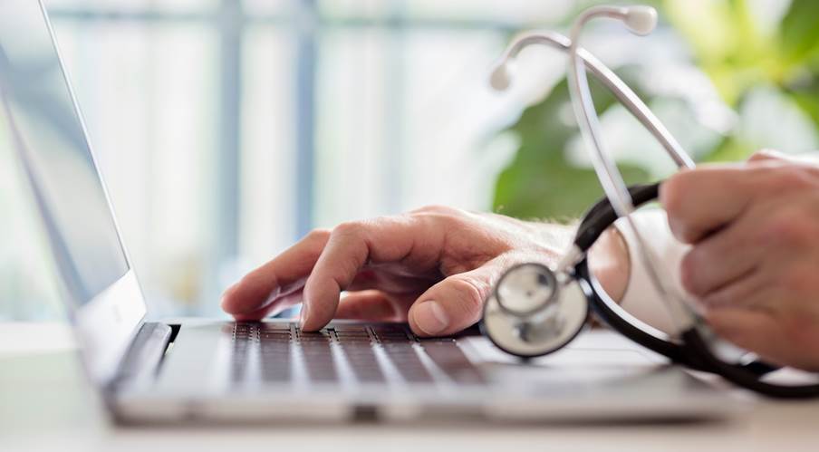 A doctor typing on a computer

Description automatically generated
