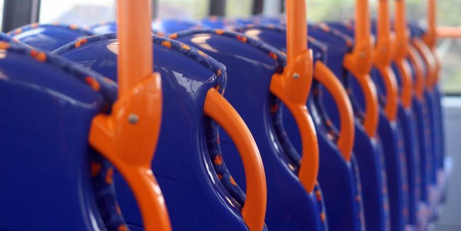 A close-up of a blue and orange bus seats
Description automatically generated